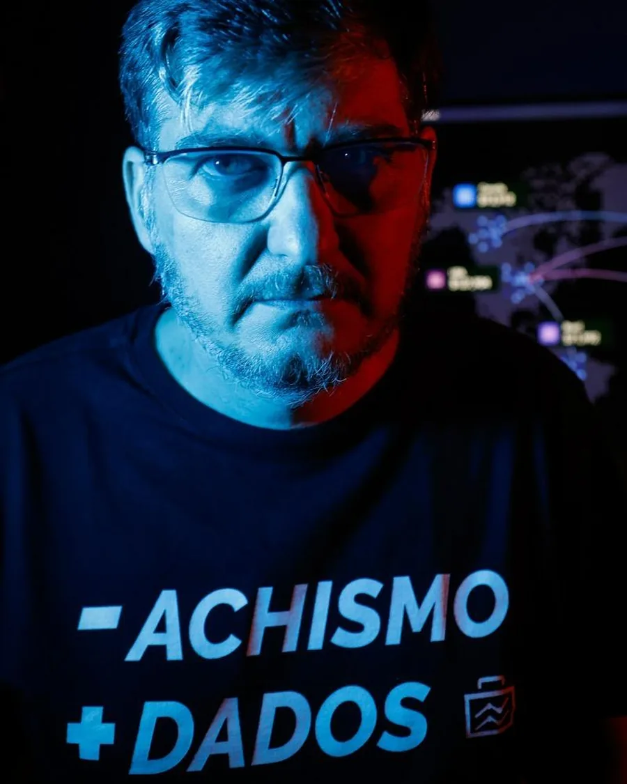 Aislan Greca com a camiseta &lsquo;-achismo +dados&rsquo;, em luz azul e vermelha